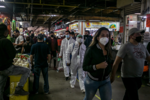 Busy marketplace with people wearing PPE